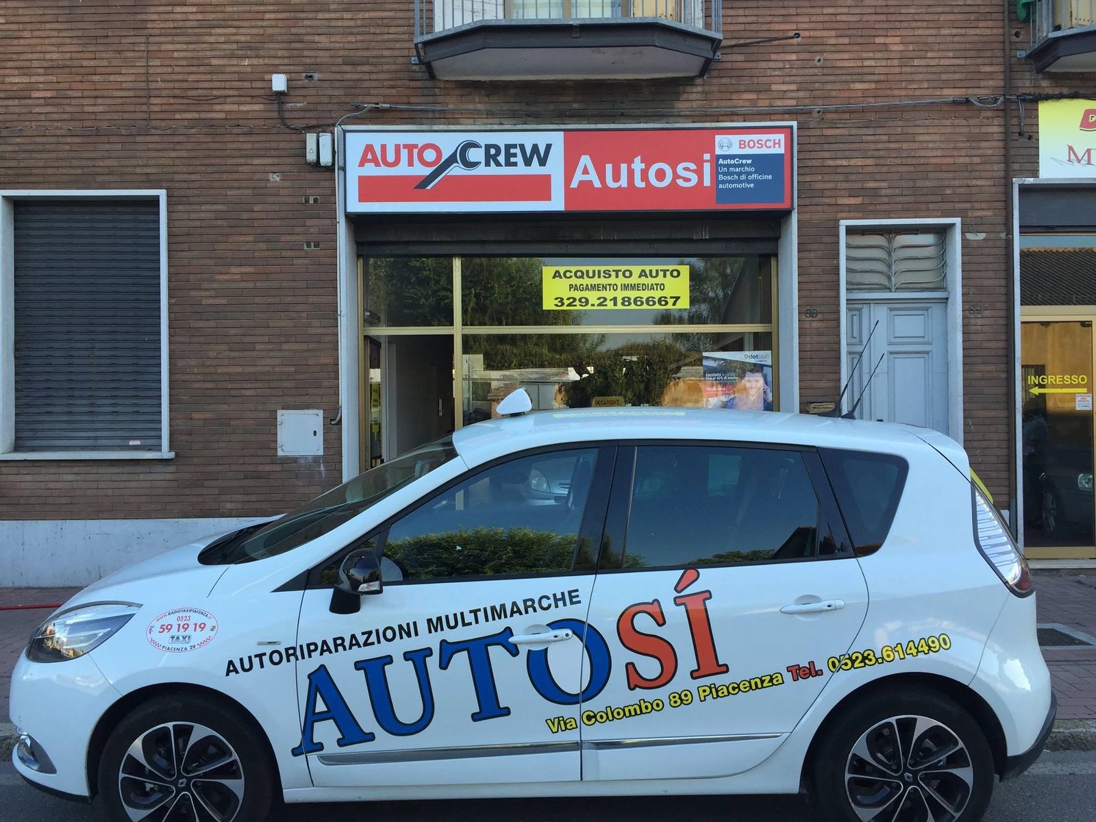 Insegna dell'officina Autosì con il marchio AutoCrew Bosch e l'auto aziendale