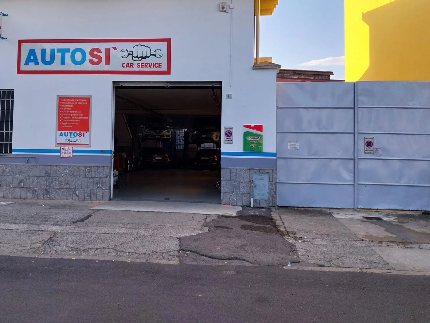 Ingresso dell'officina Autosì con l'insegna Car Service e la porta aperta sul reparto